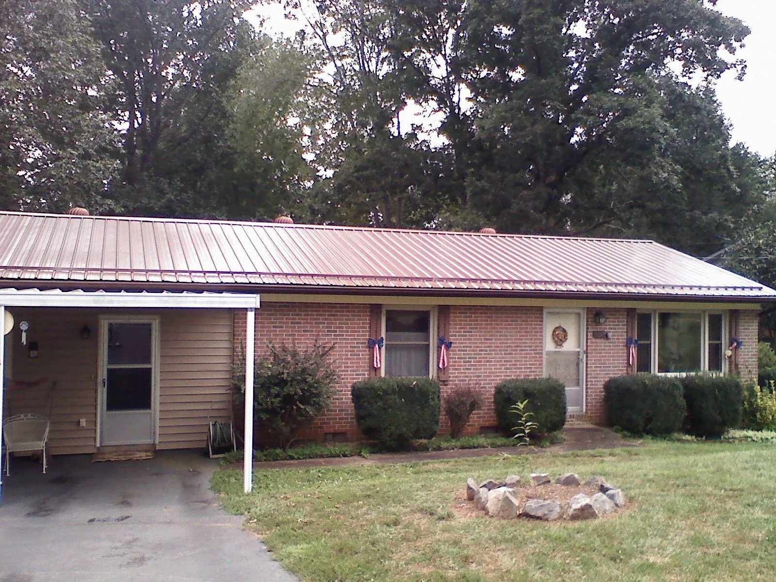 Bronze metal roof and carport on a brick ranch home — Roof Repair work by our crew in Roswell