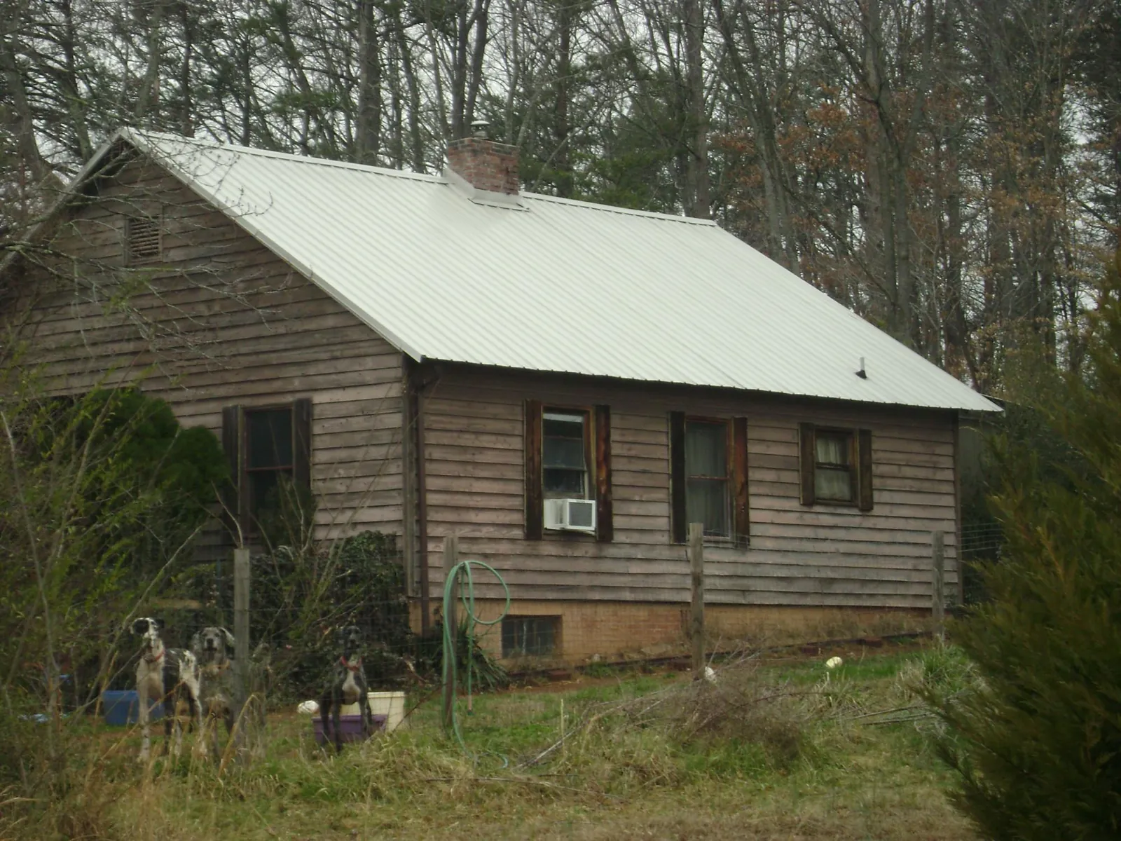 White metal roof on an old wood sided farmhouse, from a Metal Roof Installation job in Roswell